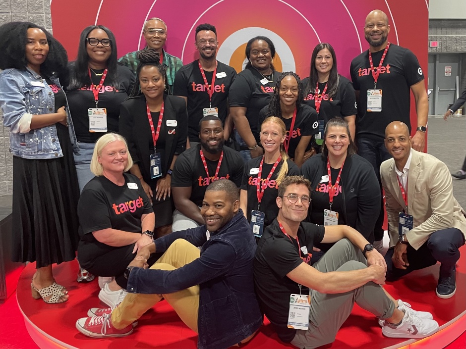 A group of Target team members pose together in front of a bullseye poster.