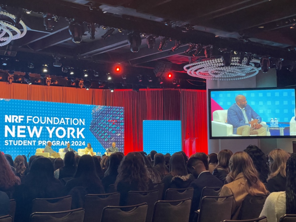 A crowd watches four people talking on a stage.
