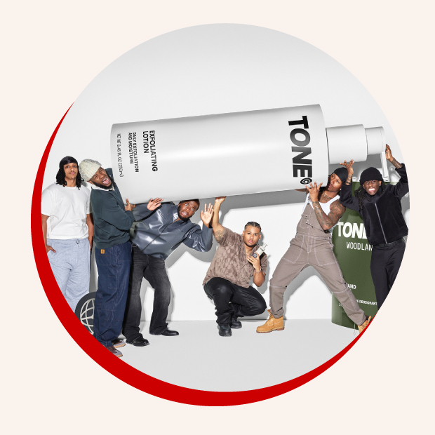 A circular photo rimmed in red of the AMP team holding up a giant white bottle that says “TONE” in black.