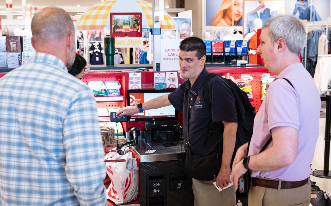 Guests with disabilities experience Target’s accessible self-checkout firsthand, assisted by team members providing friendly guidance.