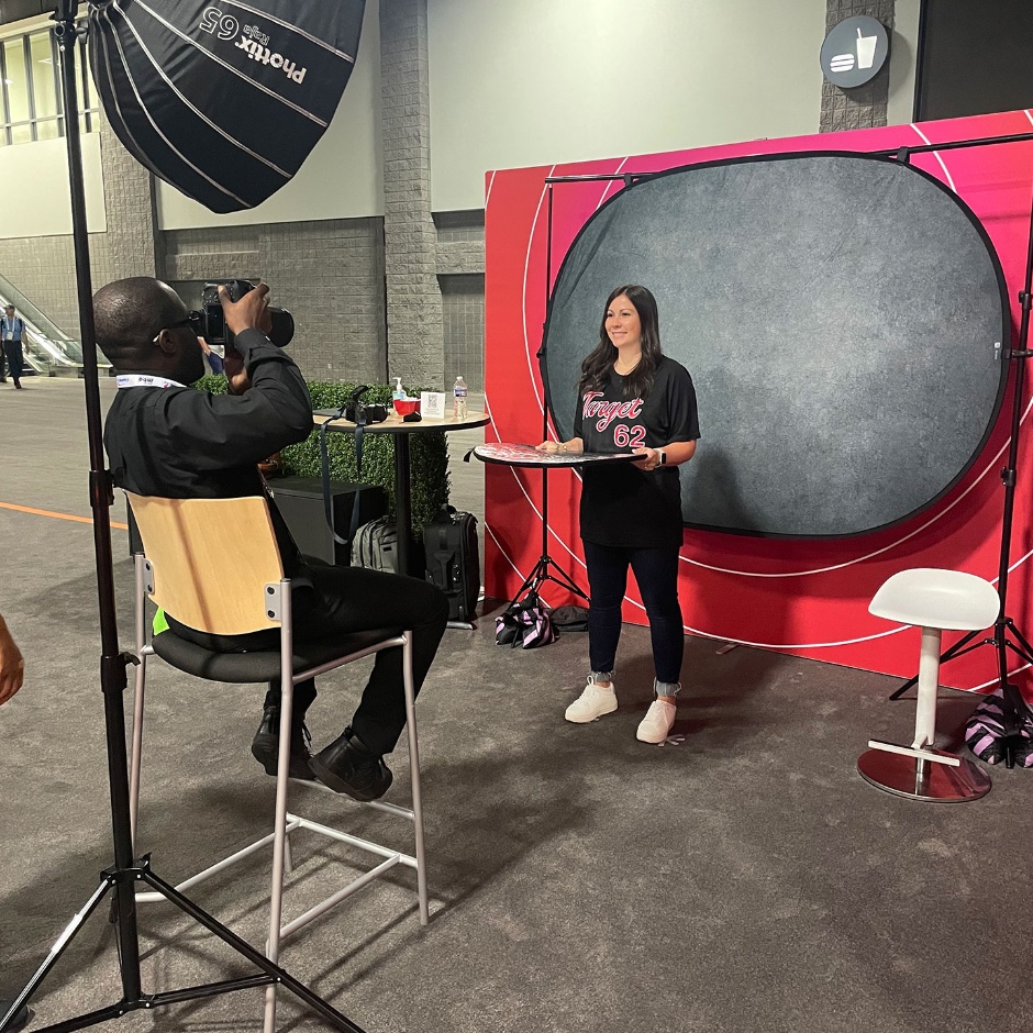 Someone gets their headshot taken in front of a black background.
