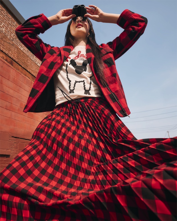 Model styled in apparel and holding binoculars from the Woolrich x Target collection