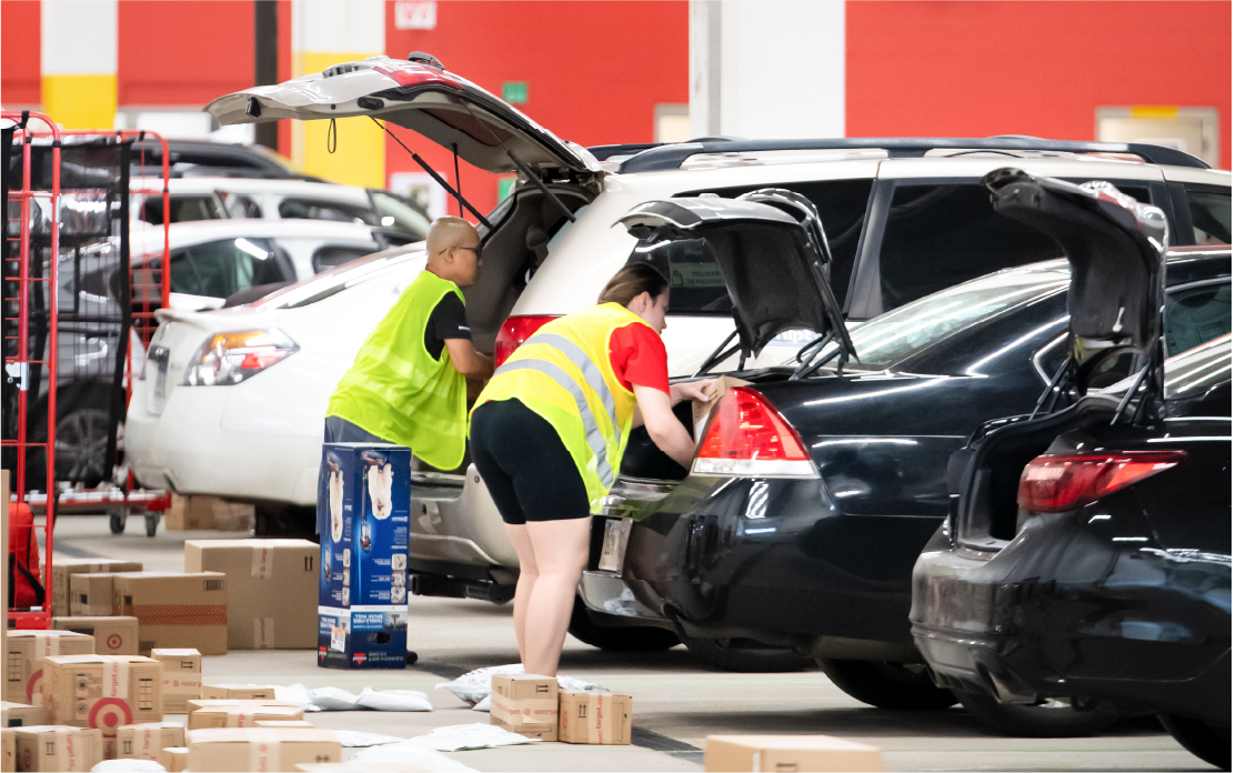 Two Shipt drivers place packages into their vehicles.