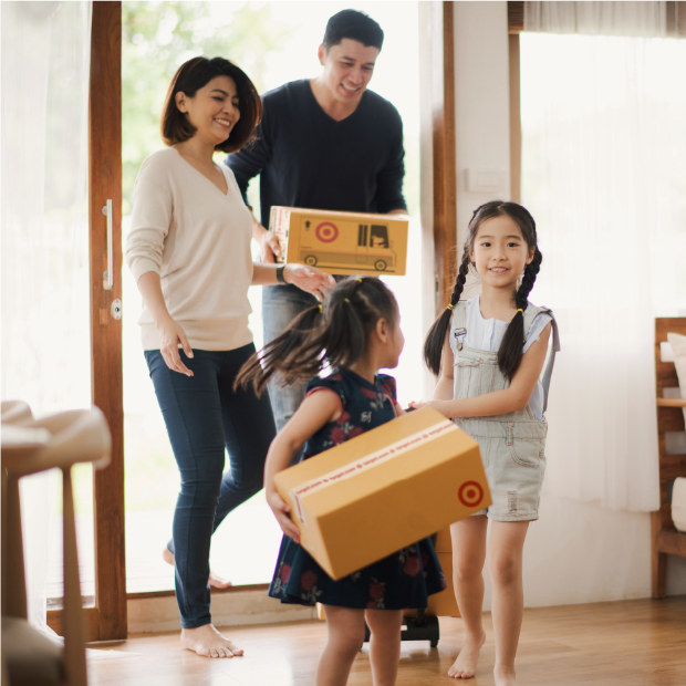A family stands in an entryway holding a Target box.
