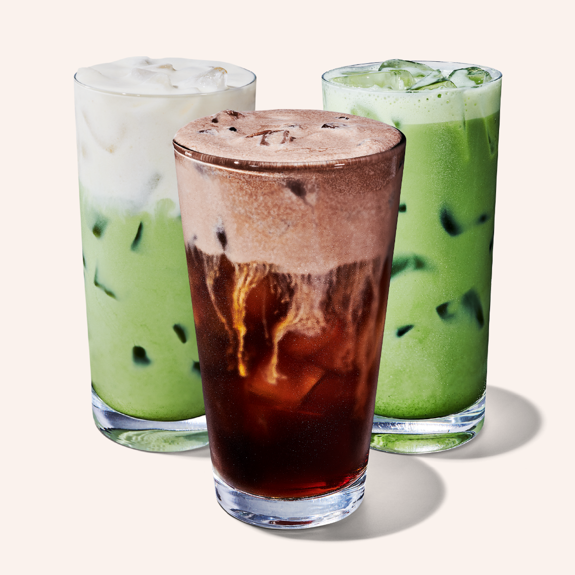Three tall glasses of liquid, one brown and two green.